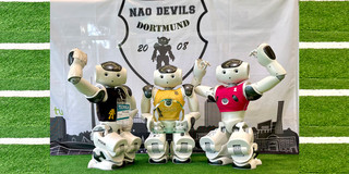 Drei Fussballroboter in Siegerpose