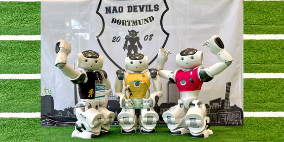 Drei Fussballroboter in Siegerpose