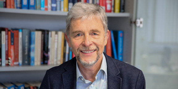 Prof. Kays Portrait vor Bücherregal