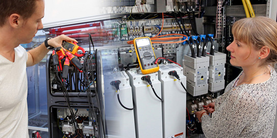 Technisches Equipment in SmartGrid Halle mit Mitarbeiter und Mitarbeiterin